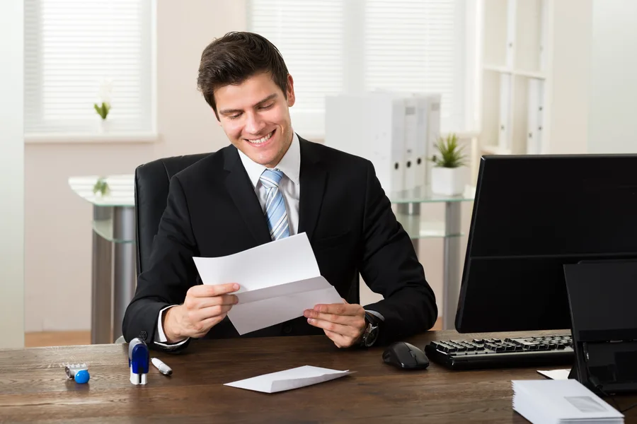 Dirigeant lisant un courrier de prospection reçu par mailing postal